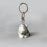 Adorable hand-carved wooden cat keychain with a happy expression